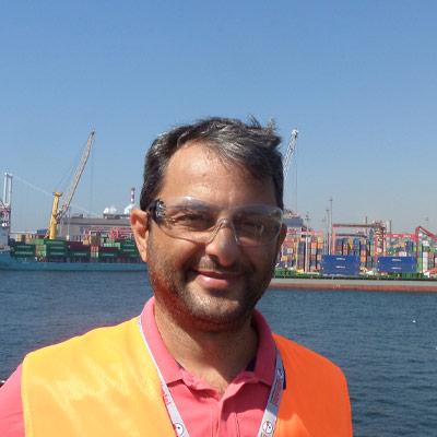 Person in hi-vis jacket standing in front of industrial waterfront