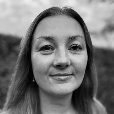 A black-and-white photo of a woman smiling at the camera