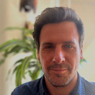 A brown-haired man smiling at the camera