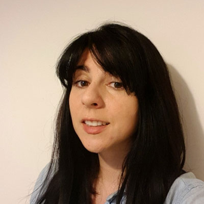 Headshot of someone with long dark hair with fringe