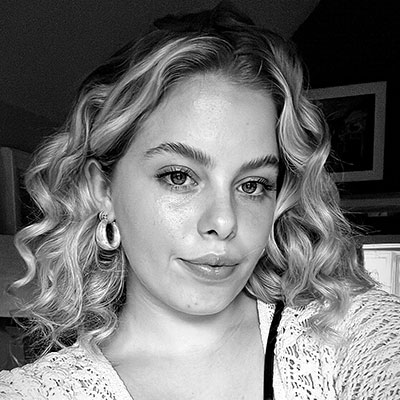 A person with blonde curly hair looking at the camera