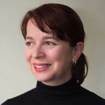 Headshot photo of a smiling woman with a ponytail