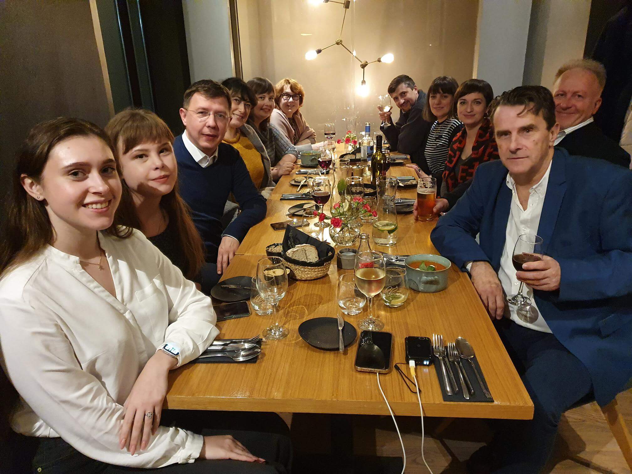 A group of academics sit around a dining table to share a meal