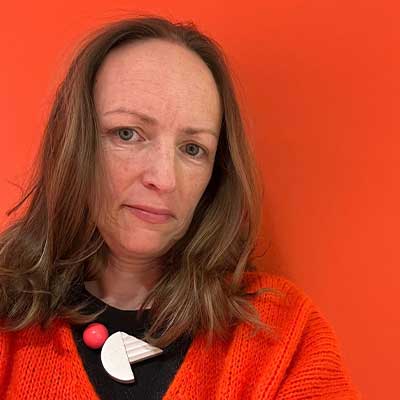 A person wearing a red jumper against a red background