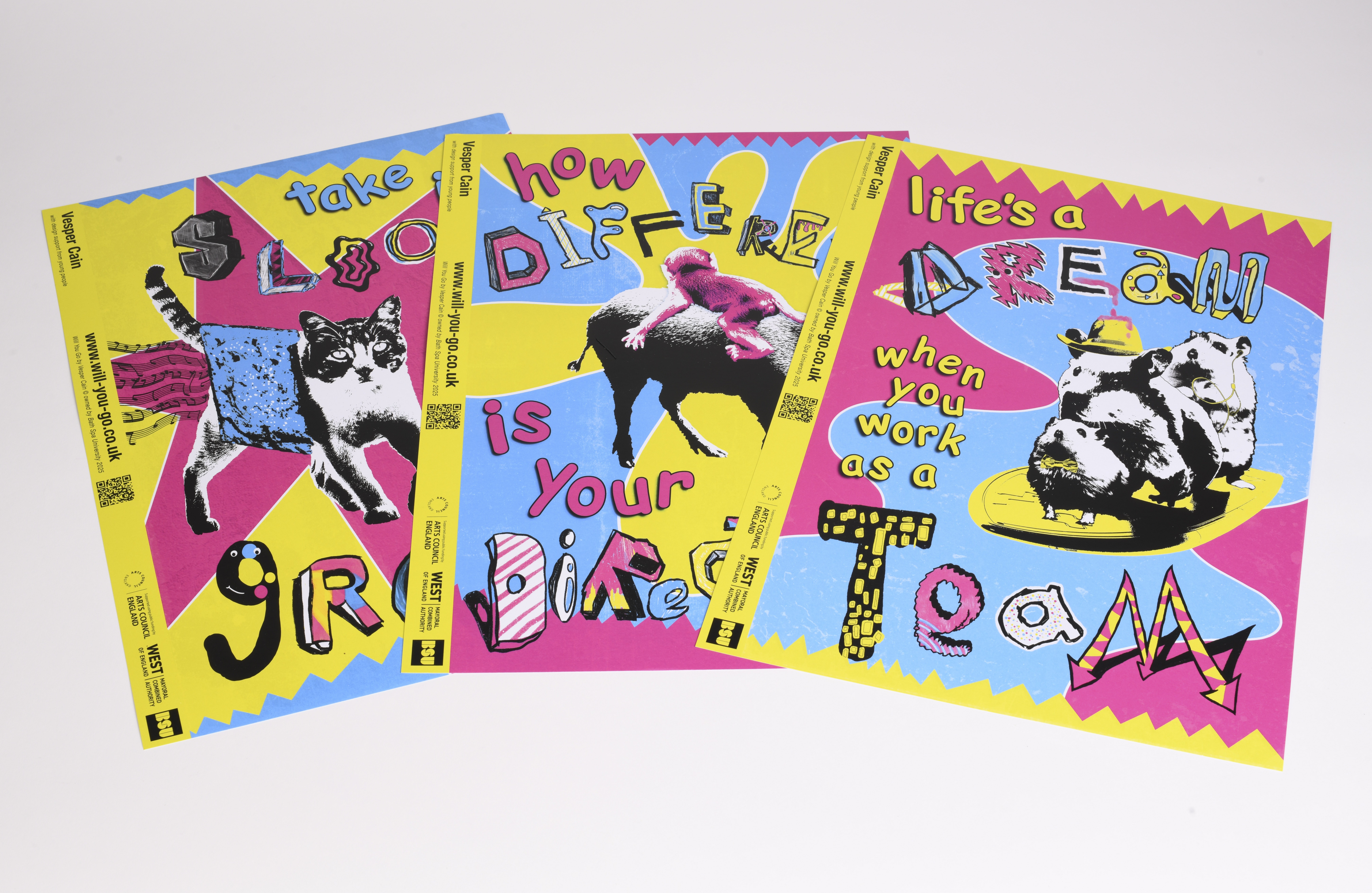 Three colourful printed posters lying on a table