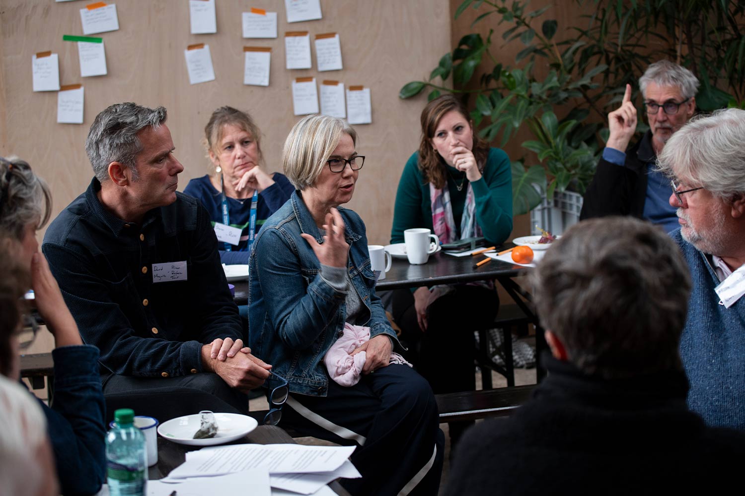 Photograph of people sitting at tables in discussion