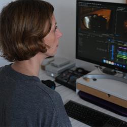 Photo of someone with shoulder-length hair looking at a screen