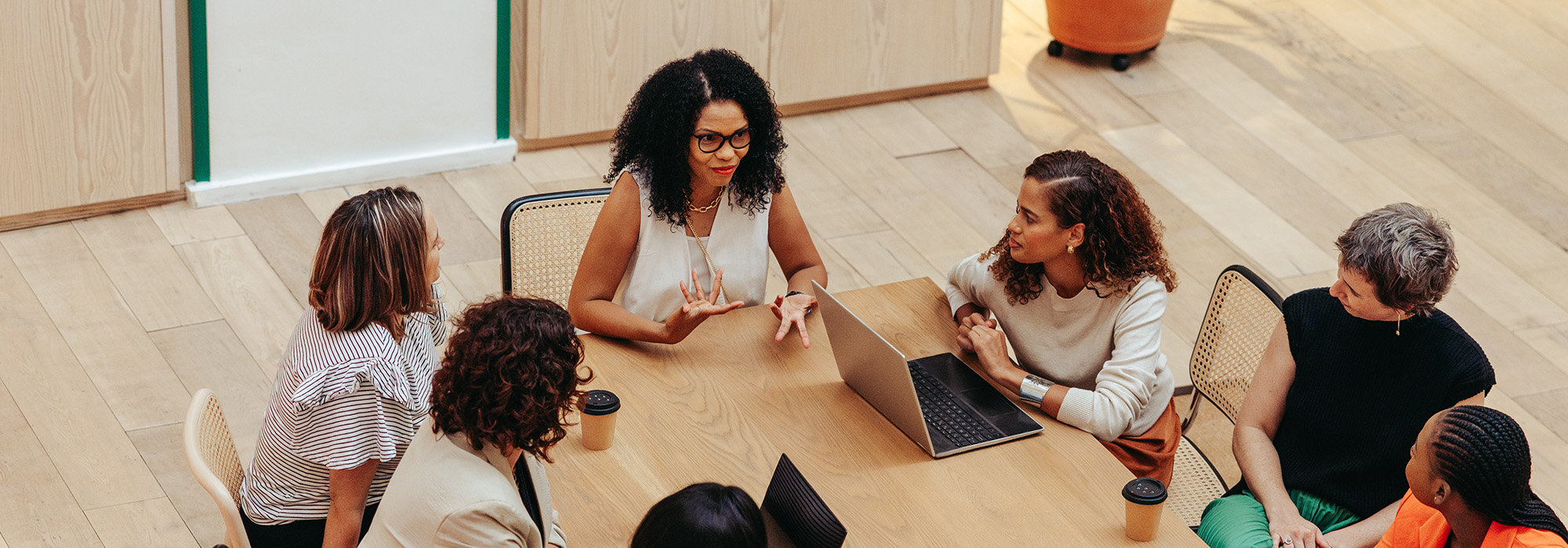 An elevated view of a group having a discussion around a long table