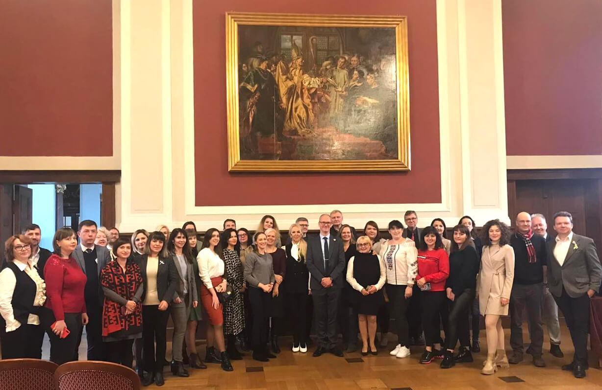 A group of academics stand underneath a large painting