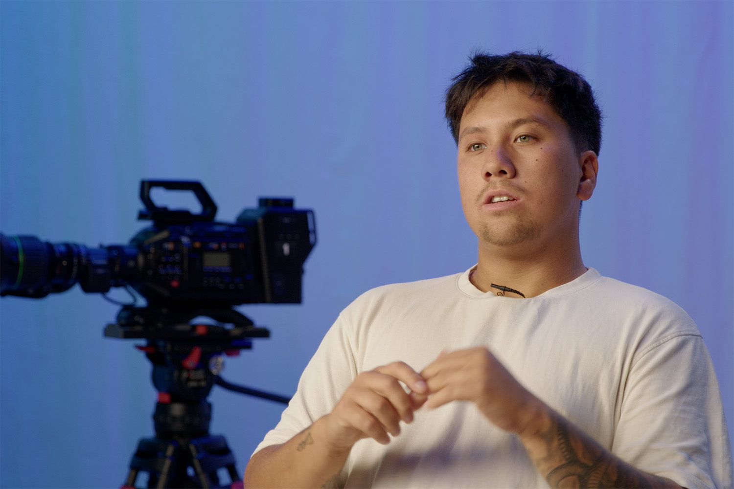 A person being interviewed in front of a film camera.