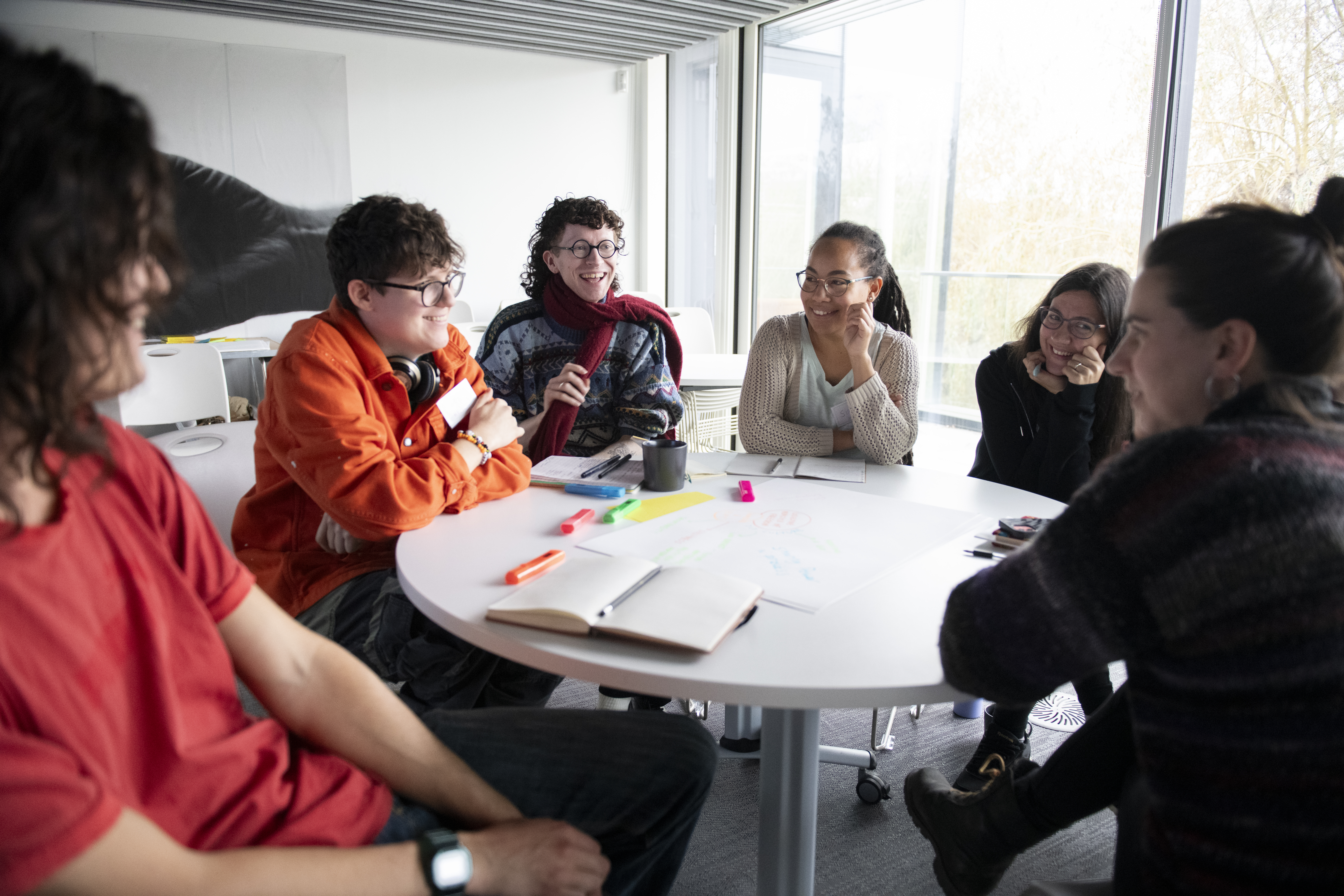A group of people sitting at a table having a discussion