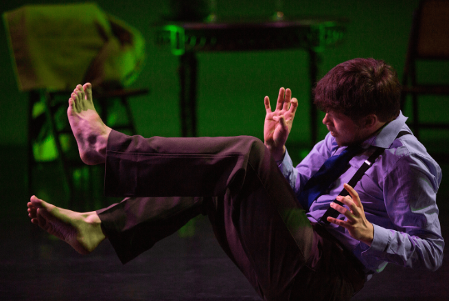 A student sits in the middle of a stage