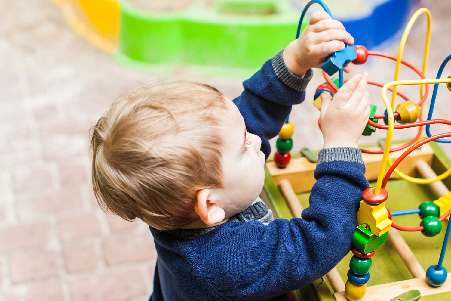 A young child plays with an abacus