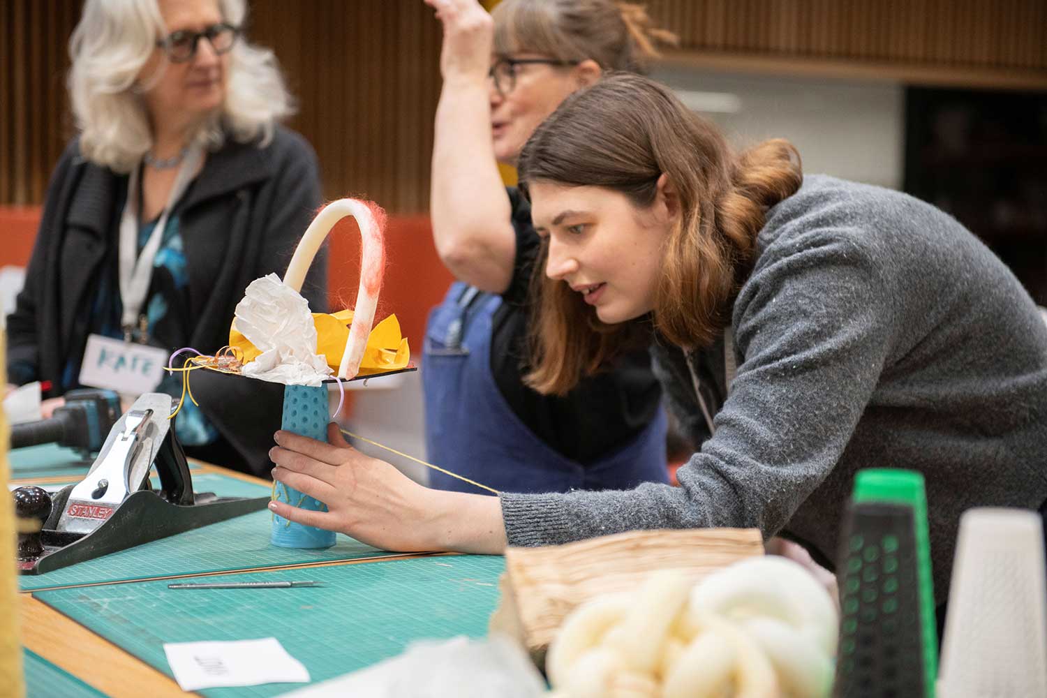 An artist leans over a piece of their work