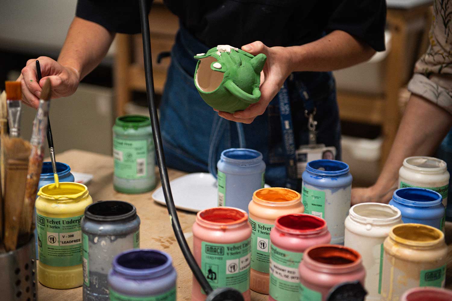 Close up photograph of painting workshop with lots of paint pots