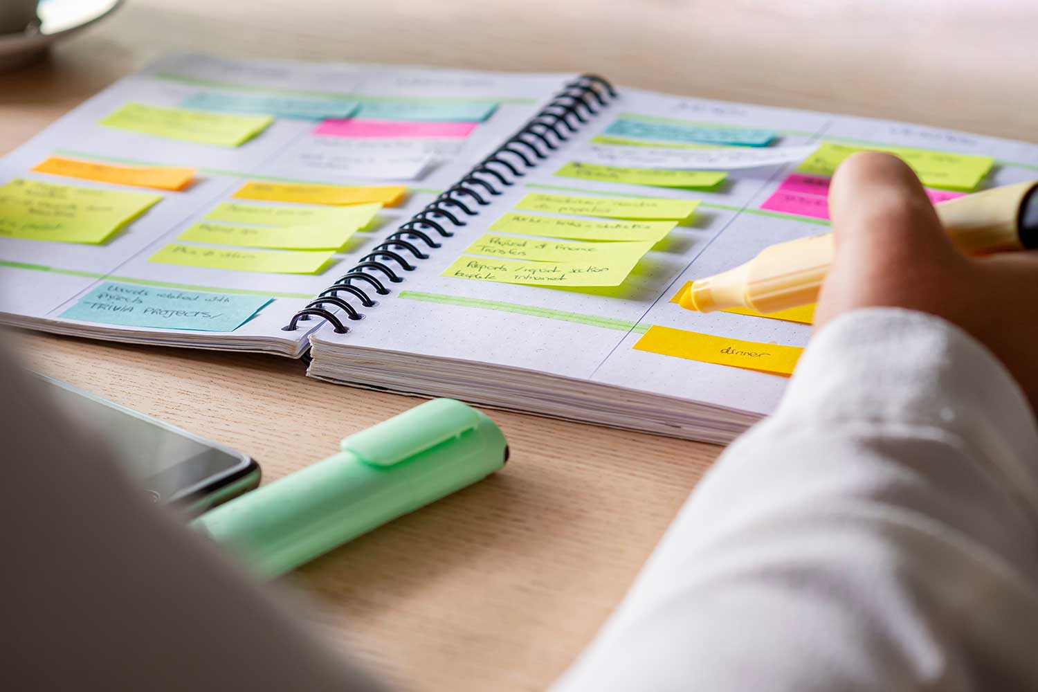 A close-up shot of a person highlighting sticky notes