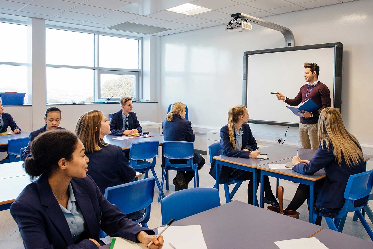 A teacher presents to a class full of pupils