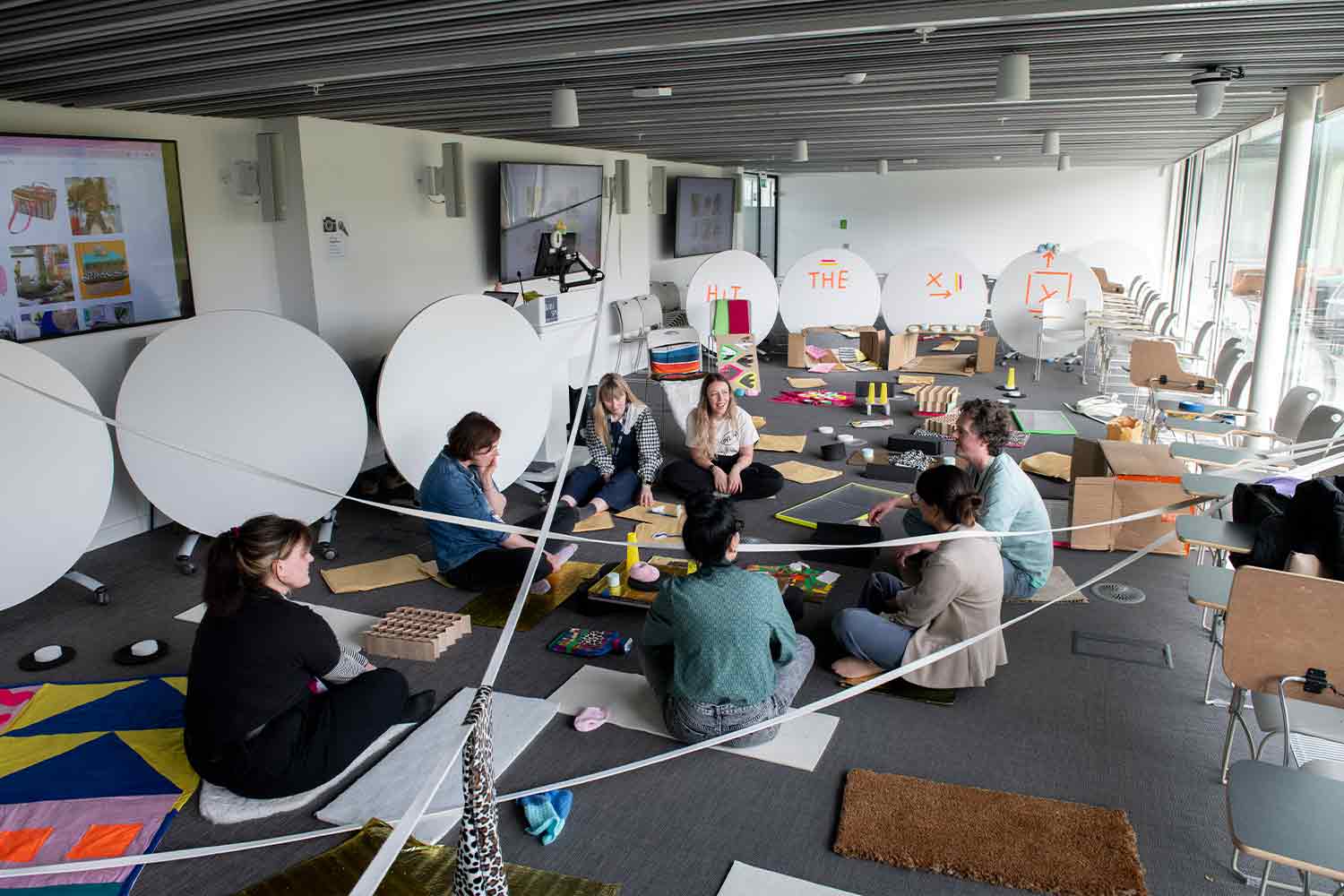 People working on craft with big white discs around the walls