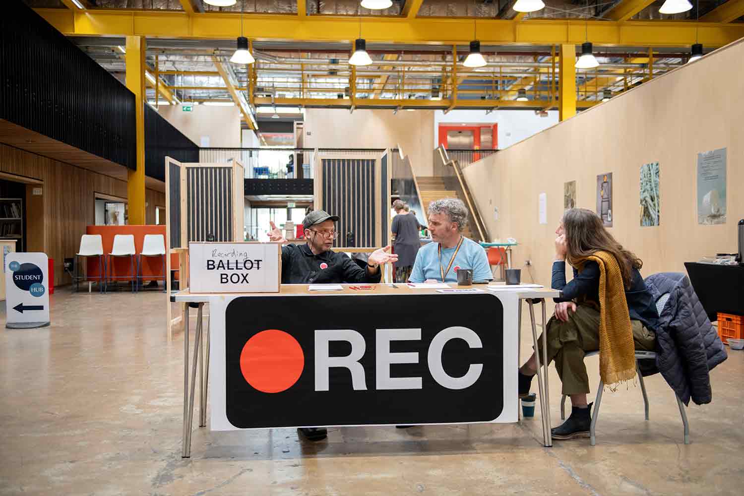 People sitting at a desk with box labelled recording box in Locksbrook campus