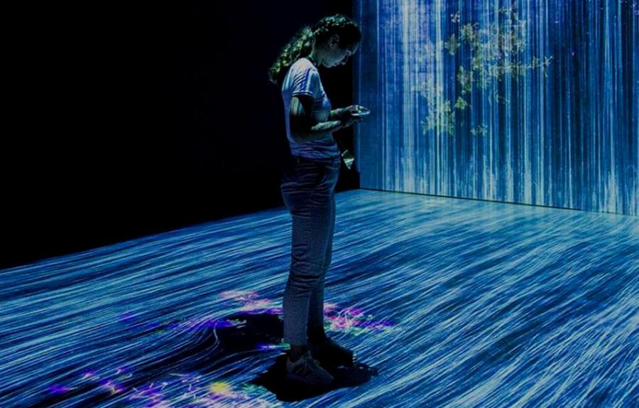 A girl standing in front of a screen with a water illusion