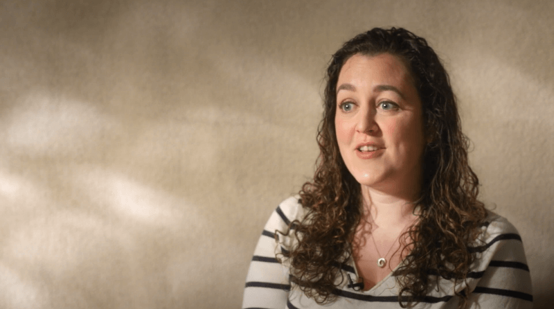 Woman talking in front of a beige background