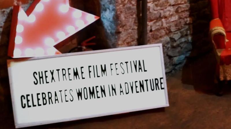 Sign with Shextreme film festival celebrates women in adventure written on it.2