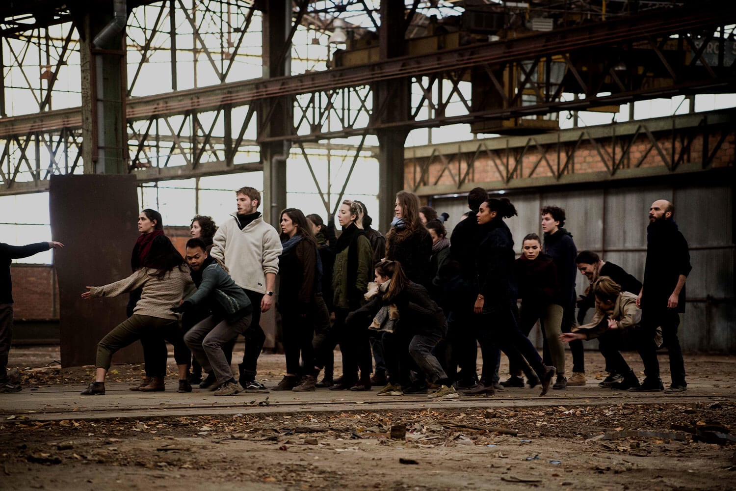 A group of dancers performing in a dilapidated warehouse