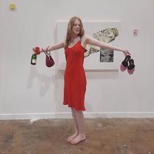 Amber Buckley posing with one of her paintings