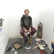 Zac Merle sitting in his studio space