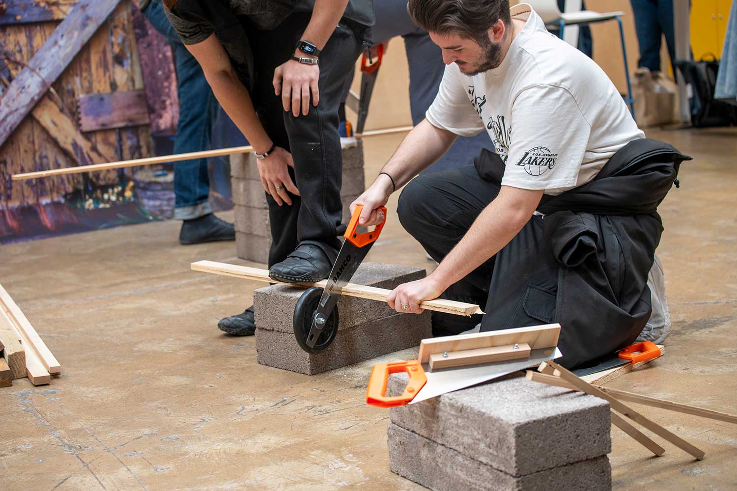 A person sawing a piece of wood