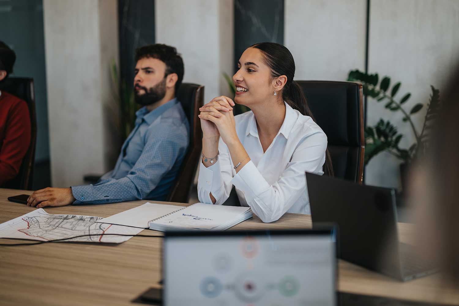 Two people sitting at a boardroom table during a meeting