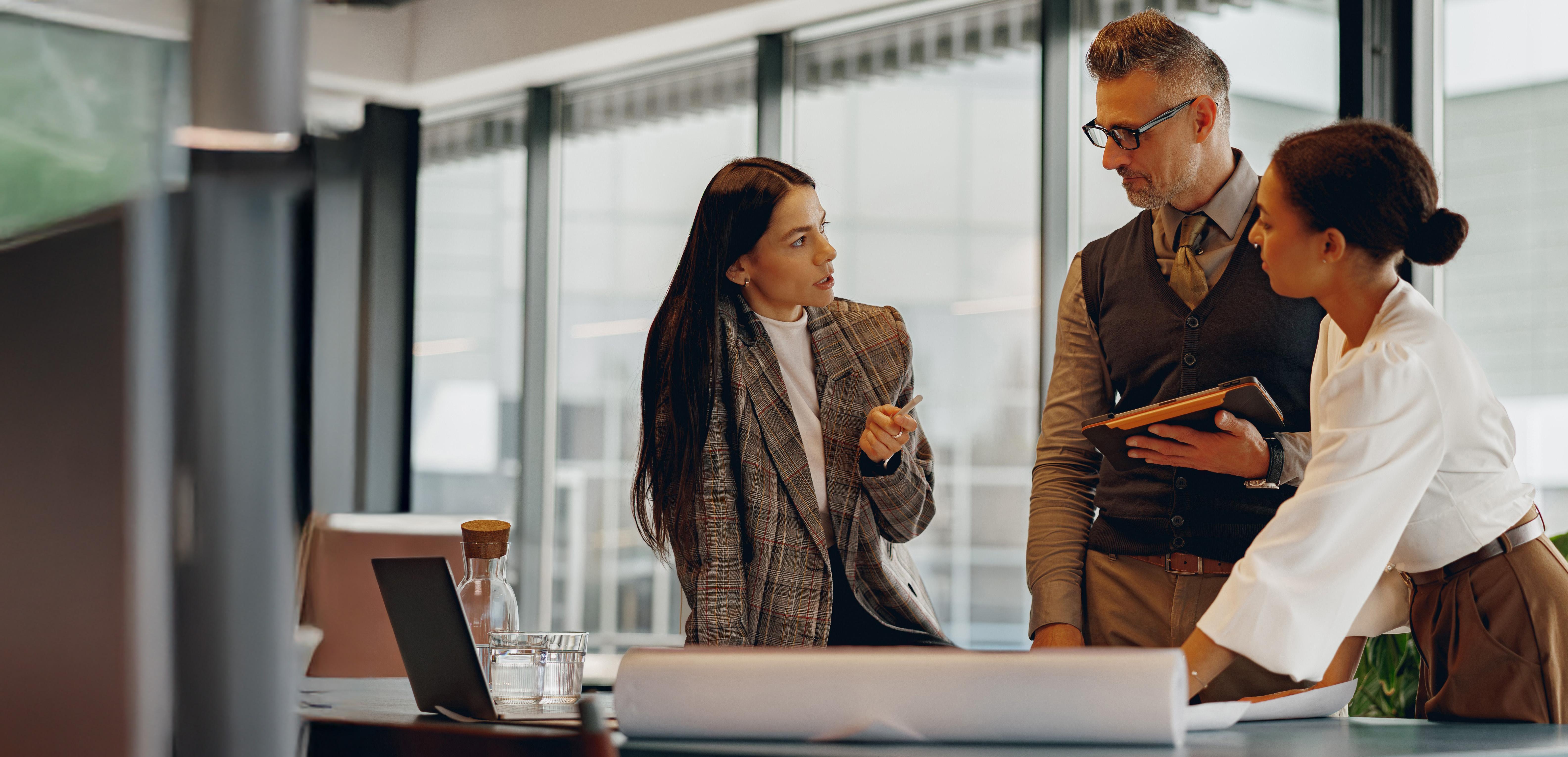 Three colleagues discuss a work-related project