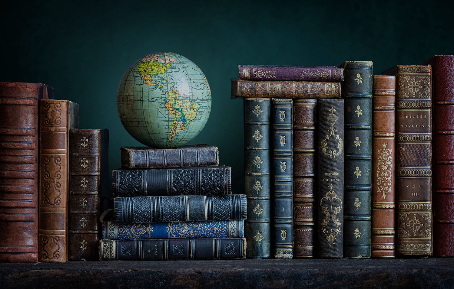 A globe sitting atop a pile of old hardback books