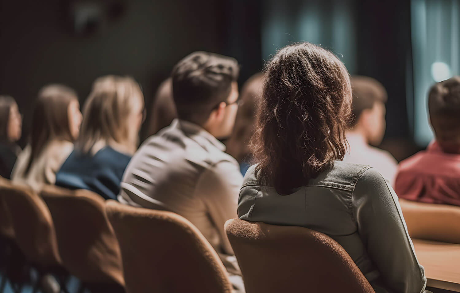 An audience listens intently to a conference presentation