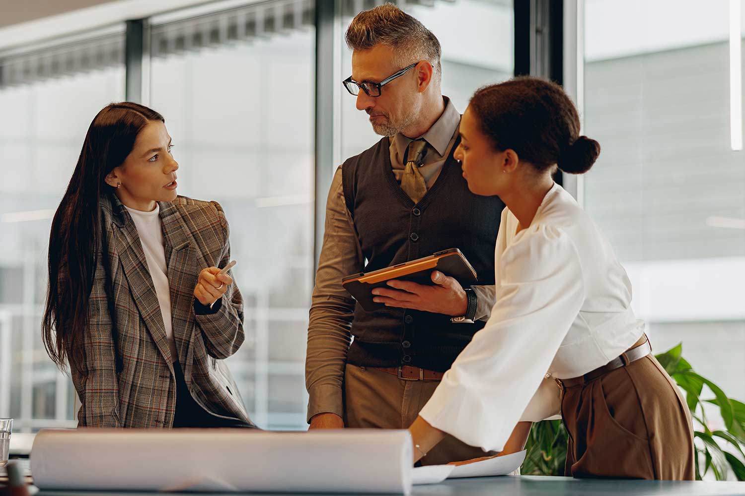 Three colleagues discuss a work-related project