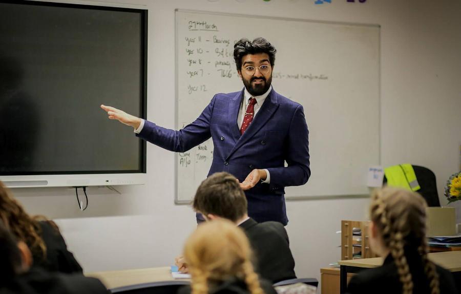 Trainee teacher addressing a classroom of pupils