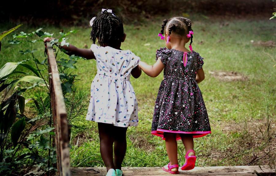 Children on a bridge holding hands