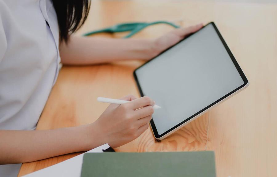 Student writing on a tablet with a stylus