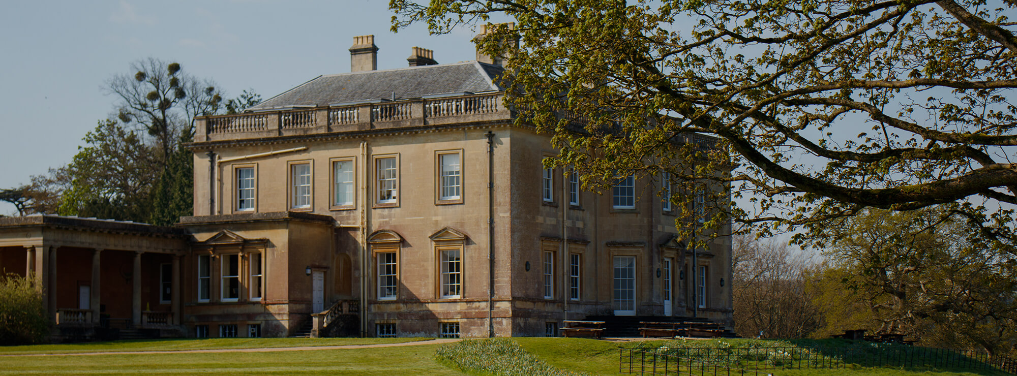 View of Main House at Newton Park campus with green surroundings.