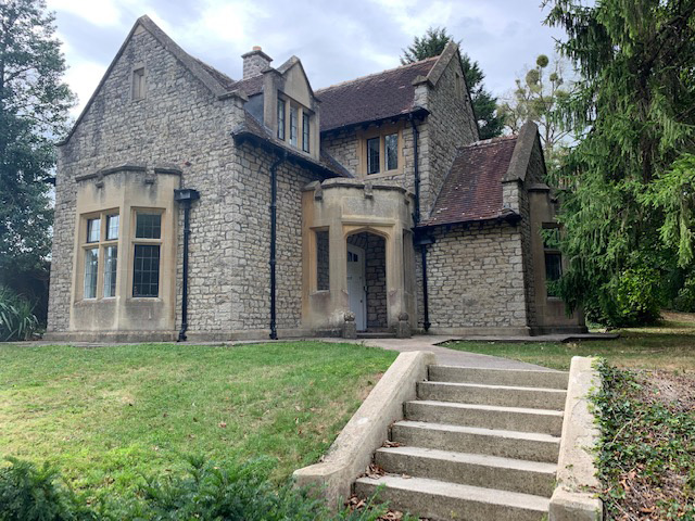 A photograph of Corston Lodge, with small steps leading up to a picturesque old stone building.