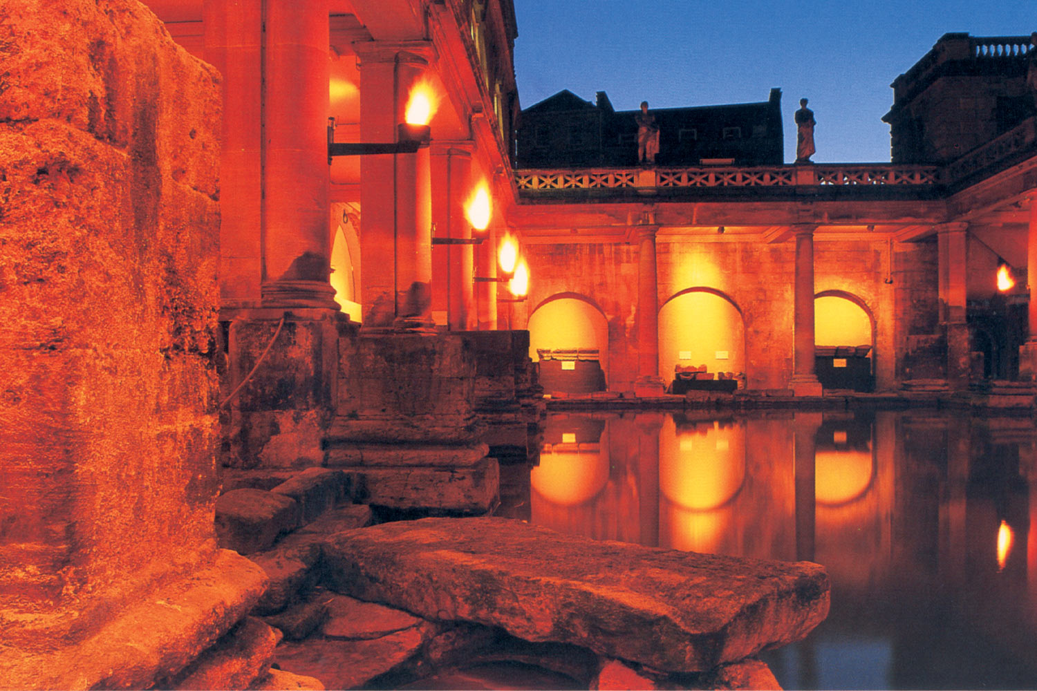 Roman Baths at night under amber lighting