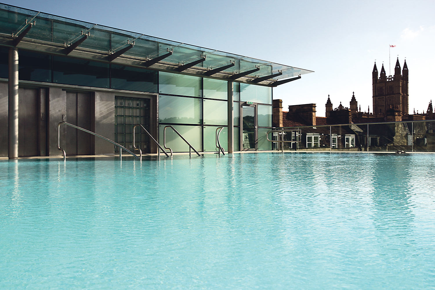 Light turquoise water rooftop pool with historic buildings in background