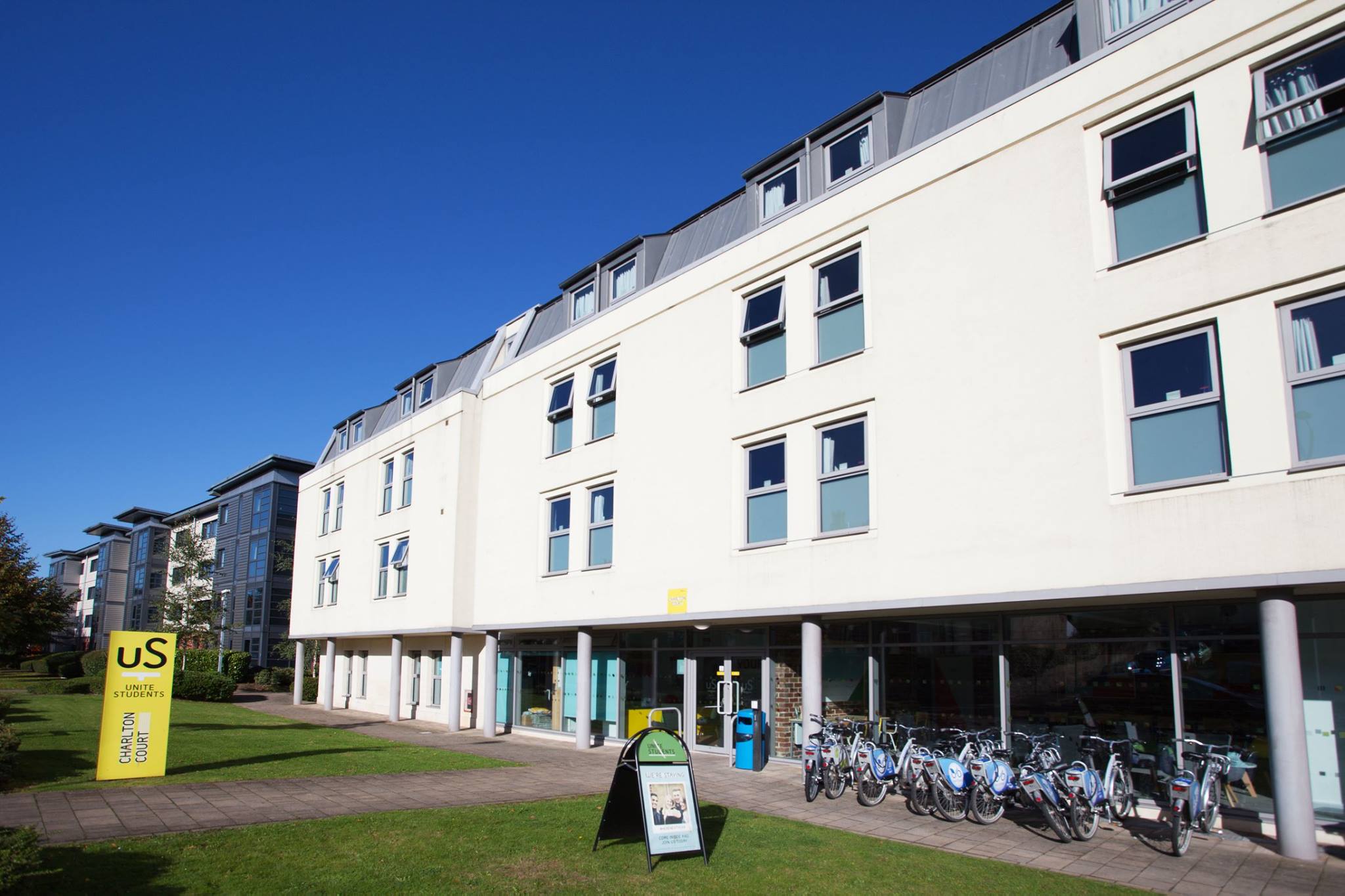 A white student accommodation building with bikes lined up outside