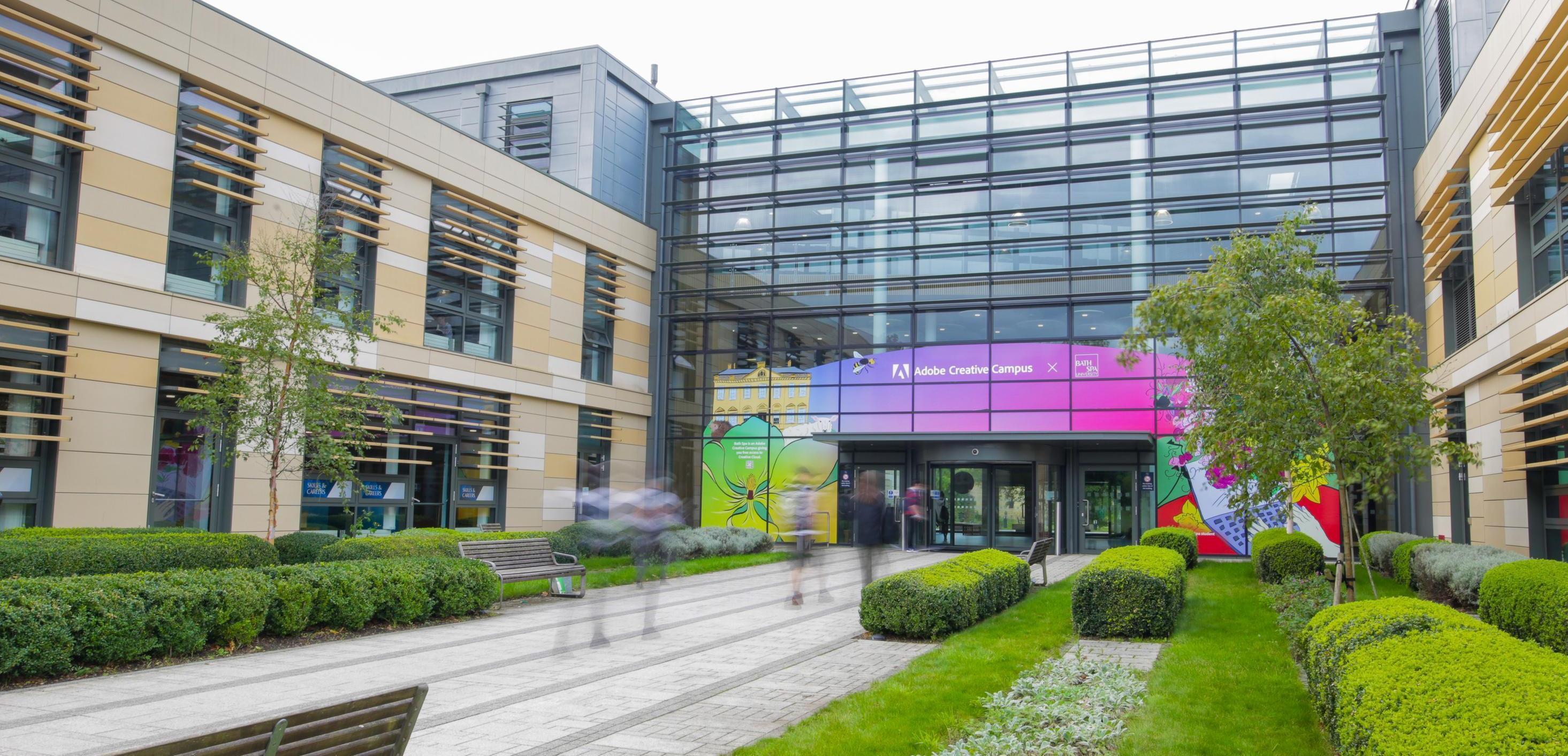  A wide angle shot of a geometric building with a path leading to large glass doors