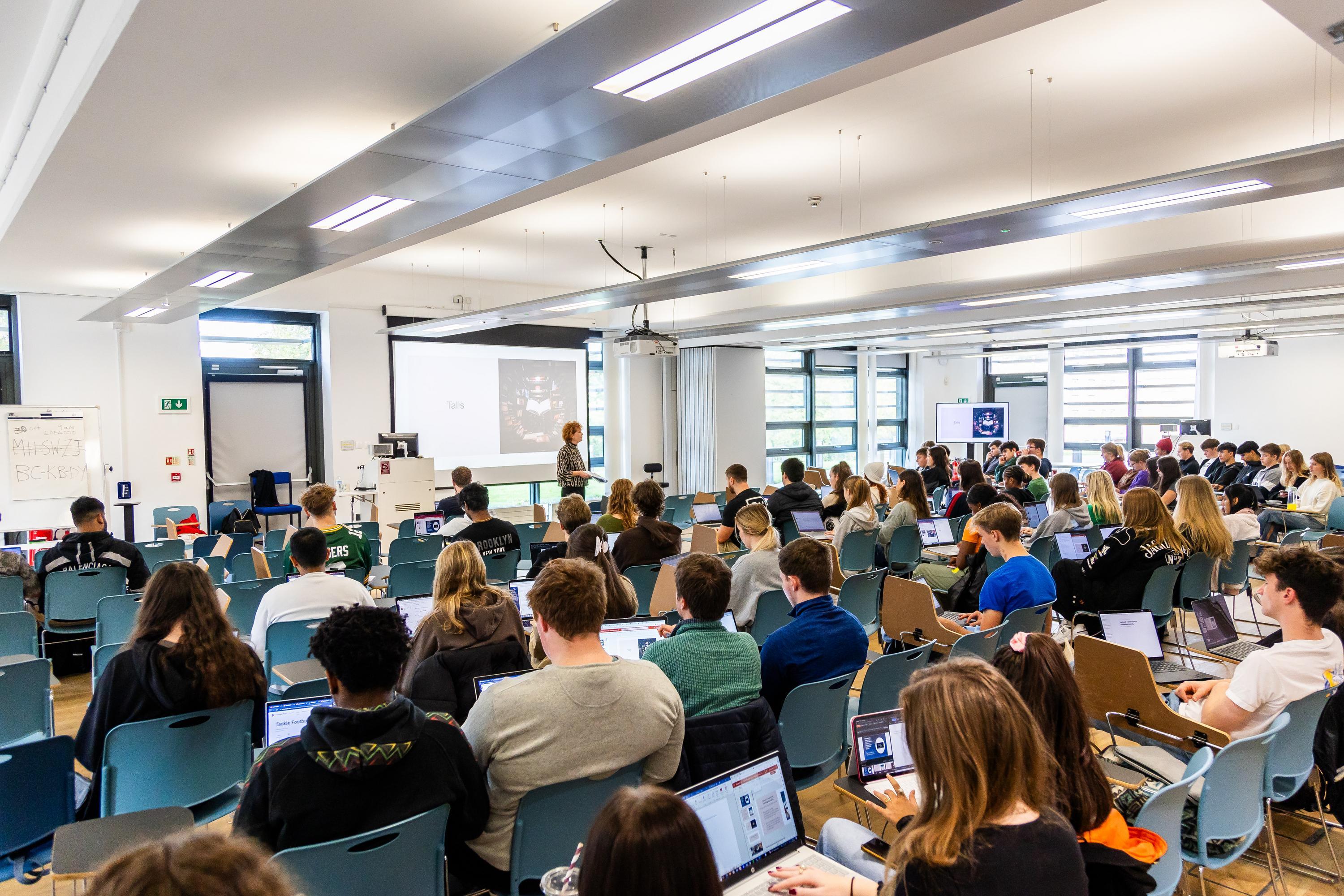 A large lecture hall full of students facing the speaker