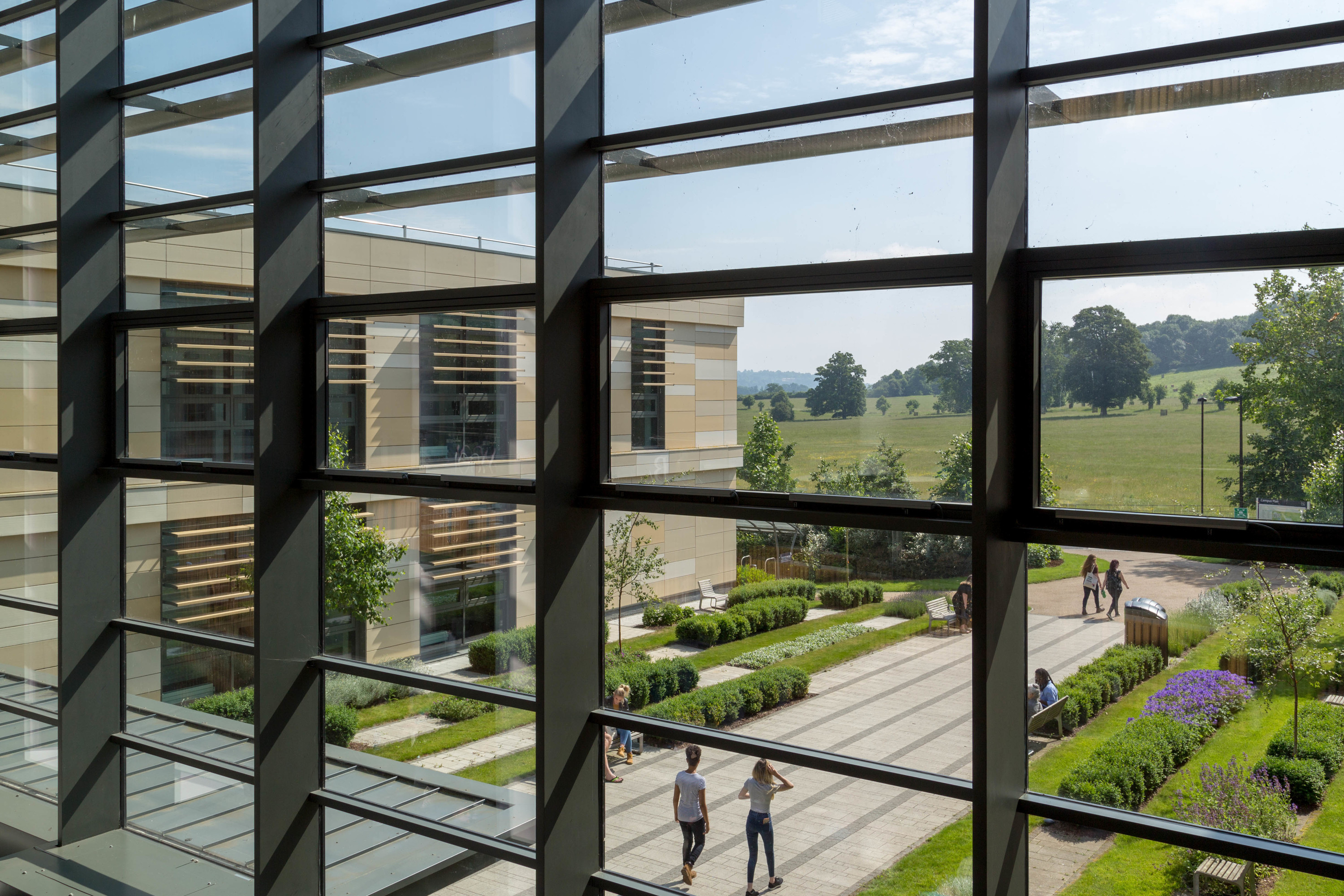A view out of a large glass window, with green fields outside