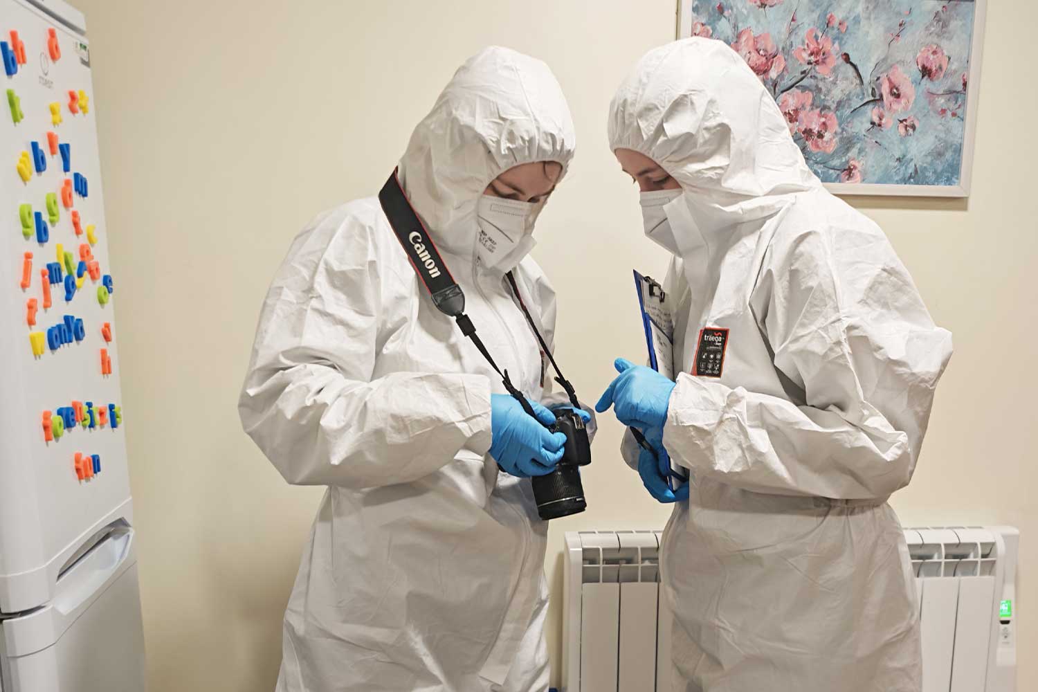 Two students lean over a camera as they gather evidence