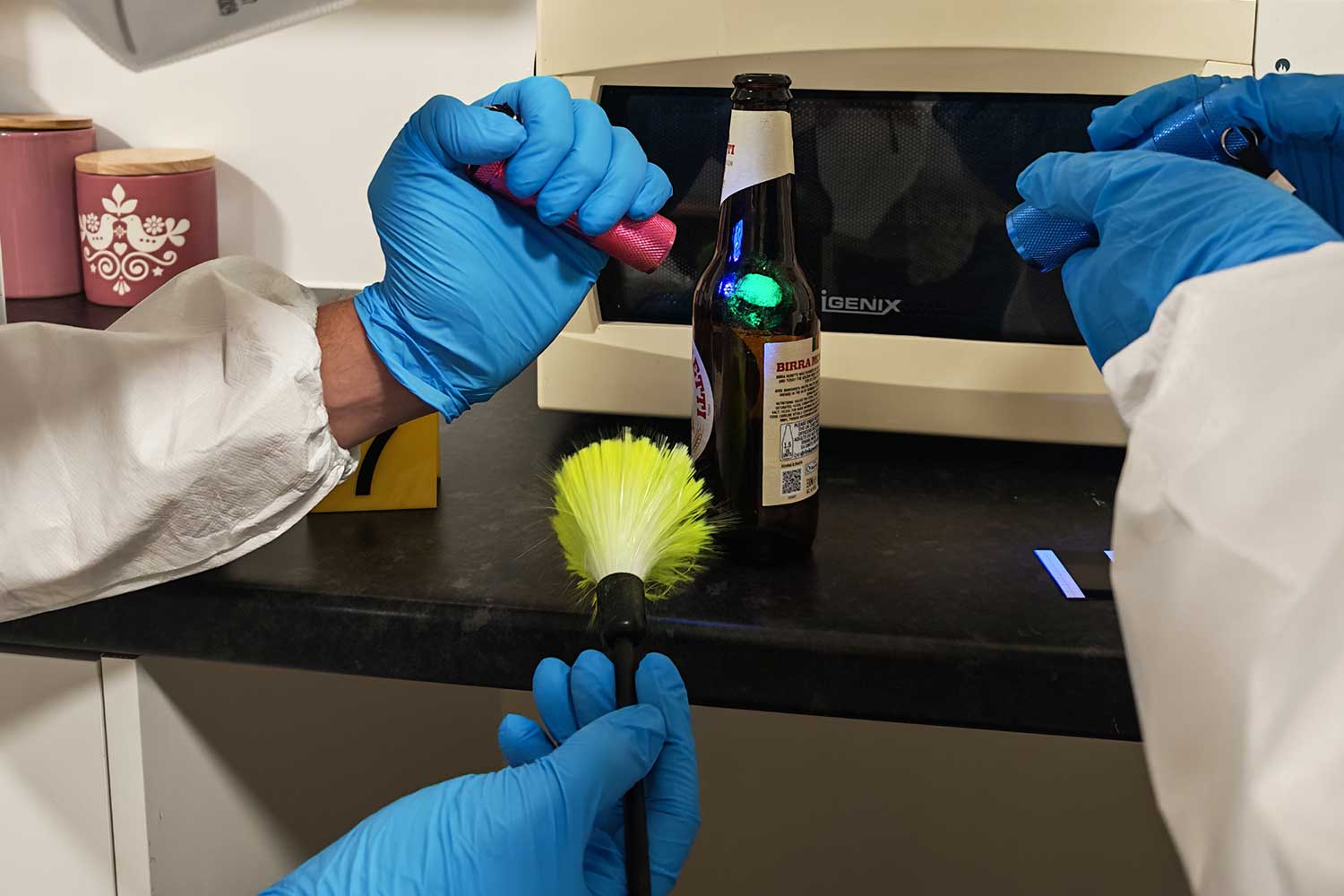 A close up of people wearing blue disposable gloves investigating an item