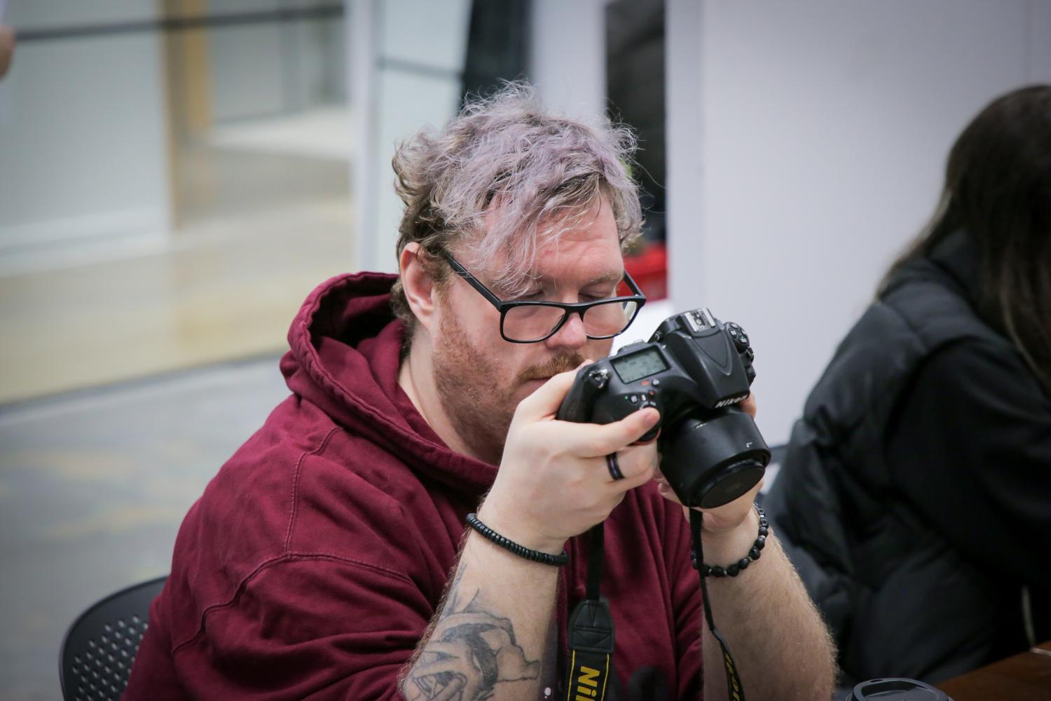 A person looking at a DSLR camera