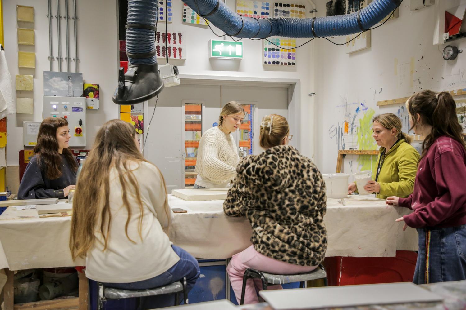 Students and a member of staff stand around a large table for a demonstration